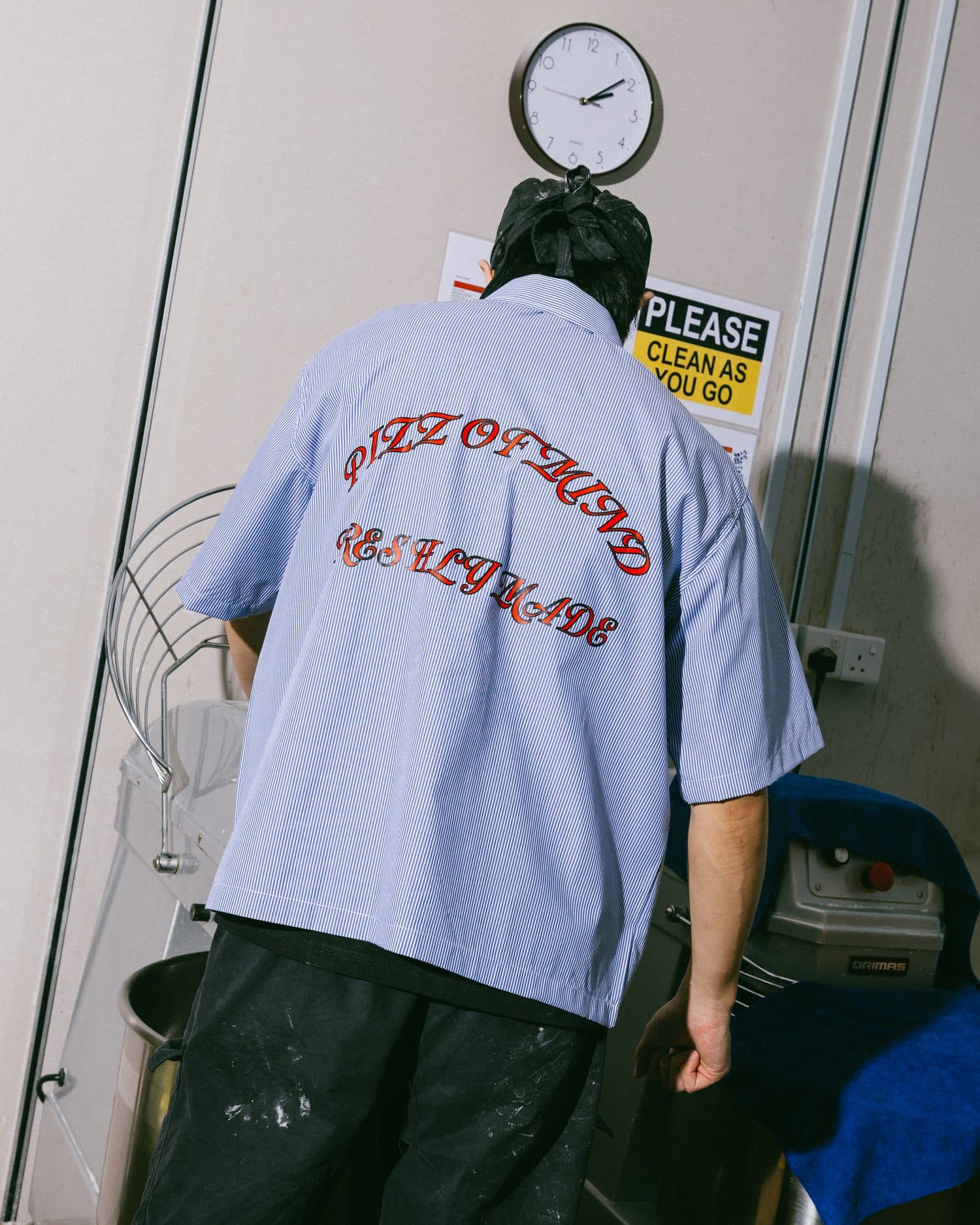 A crew member in a Pizz of Mind, Freshly Made shirt