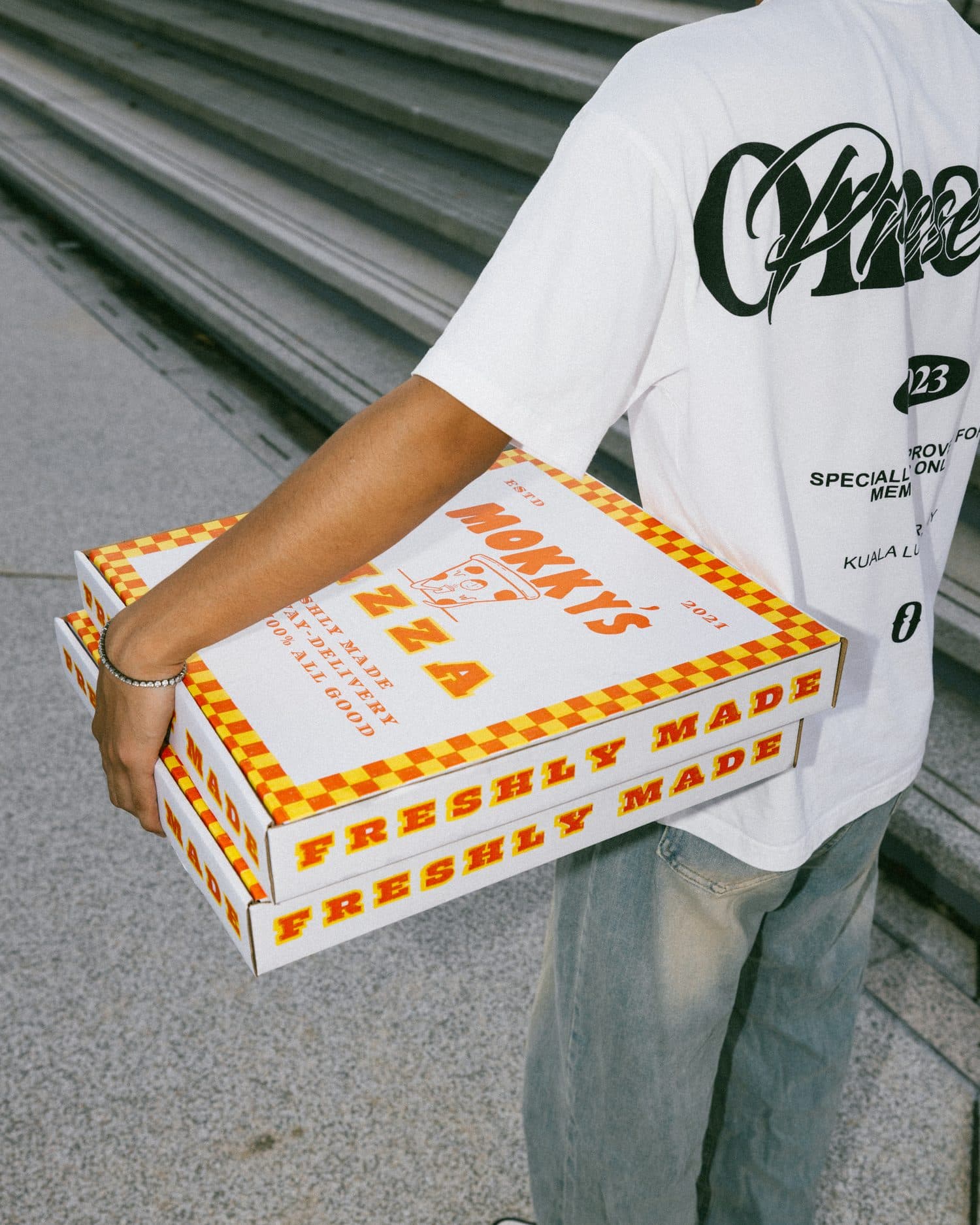 Carrying a stack of Mokky's pizza boxes