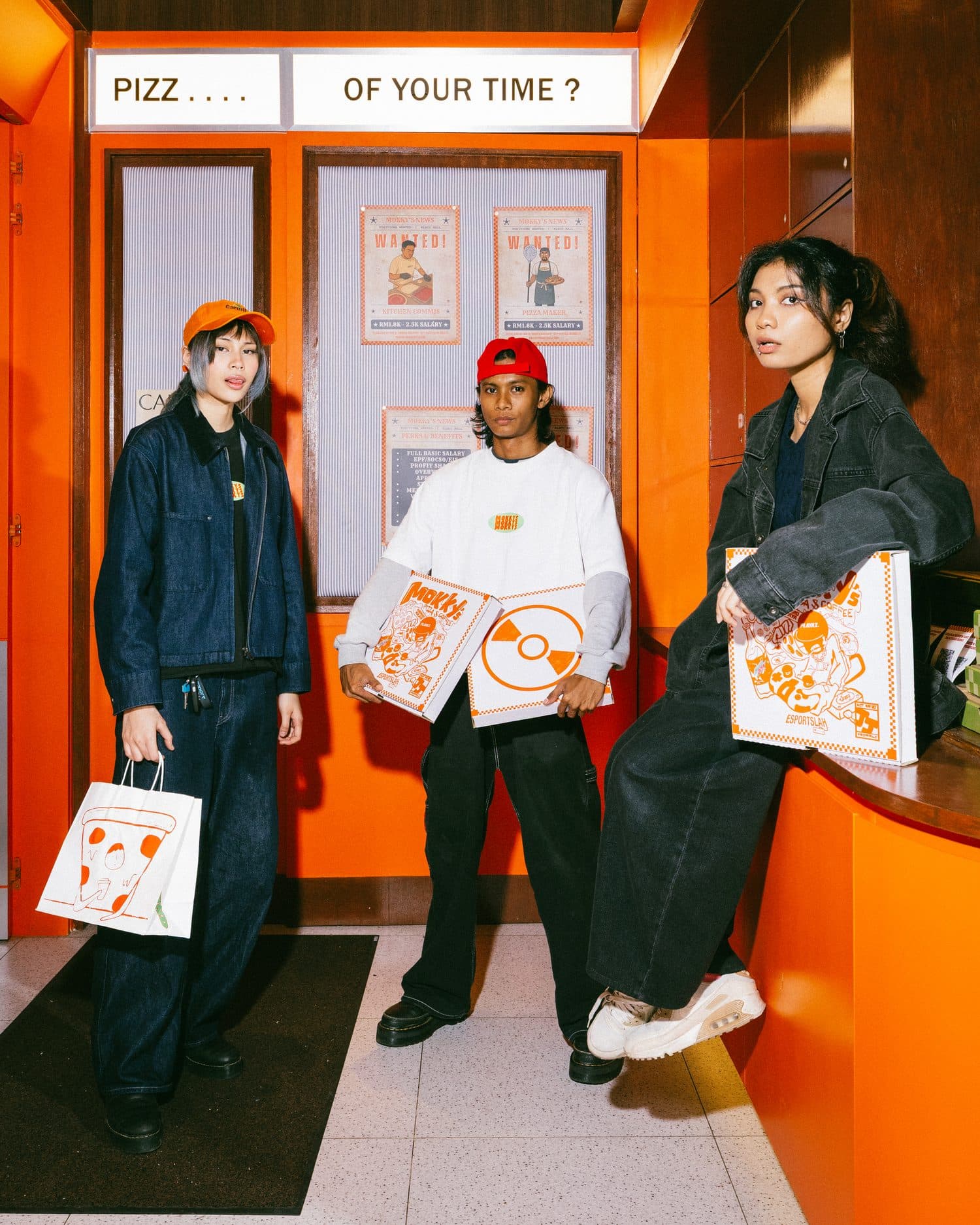 Three friends with Mokky's boxes at the orange shopfront