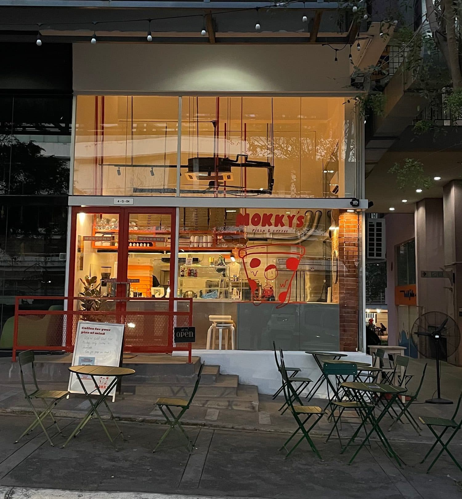 A Mokky's outlet at dusk, with tables out front